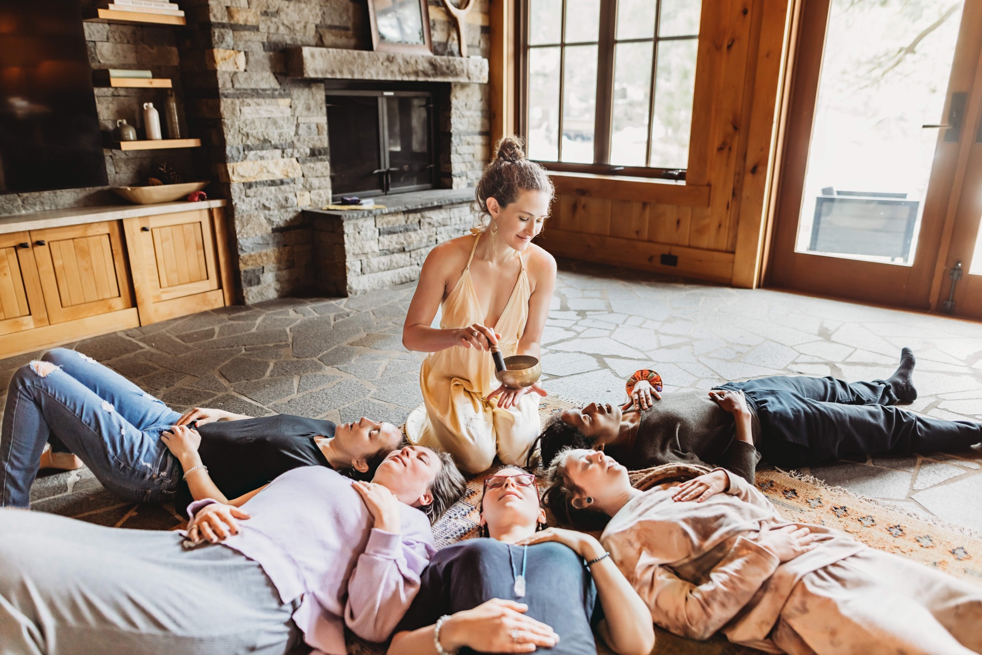 Adrienne Rivera guiding a group breathwork journey with a singing bowl at the Breath of Gold retreat house in Reno, Nevada